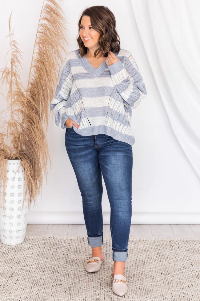 Blue jeans a blue and white striped V neck sweater and coordinating sneakers make for a charming and easy fall outfit