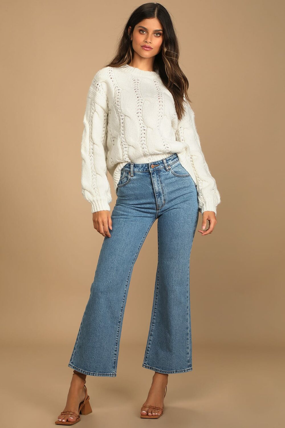 The oversized cream cable knit sweater has a rounded neckline long balloon sleeves with drop shoulders. Wear it with leggings or skinny jeans to highlight the somewhat large bodice.