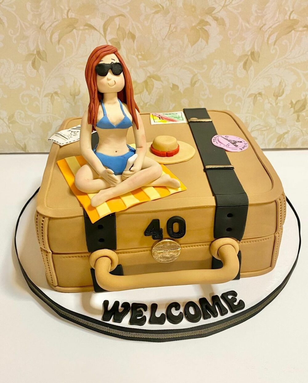 Take this beach babe sitting atop a luggage travel cake with you on your next trip.