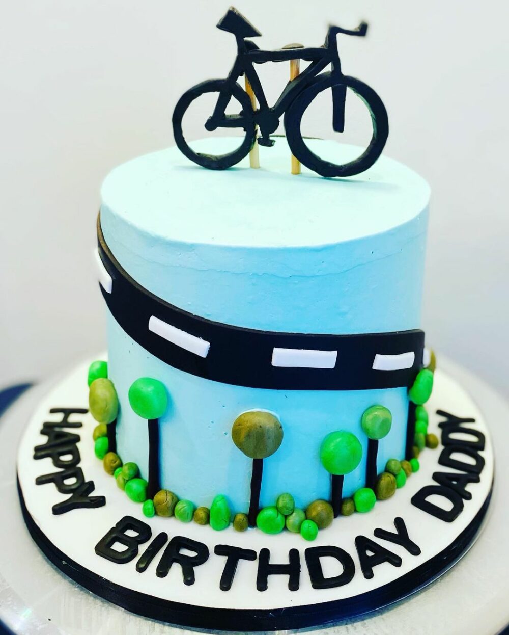 This is the greatest cake idea for any kind of traveler a blue cake adorned with black bicycles.
